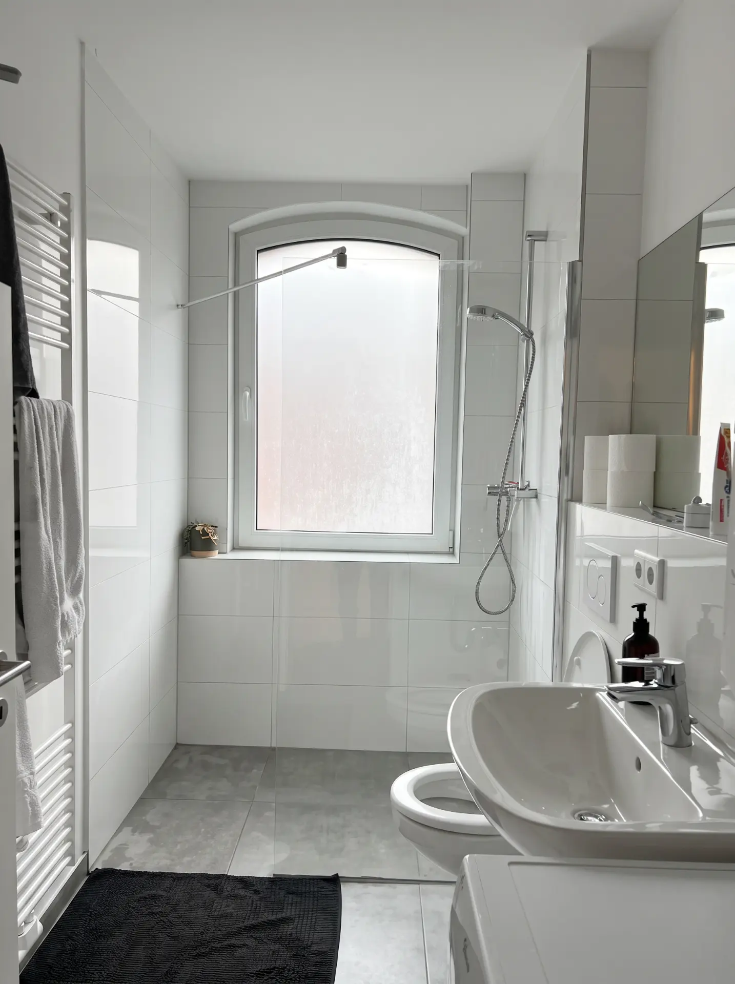 Modernisiertes Bad mit bodengleicher Dusche und großformatigen Fliesen